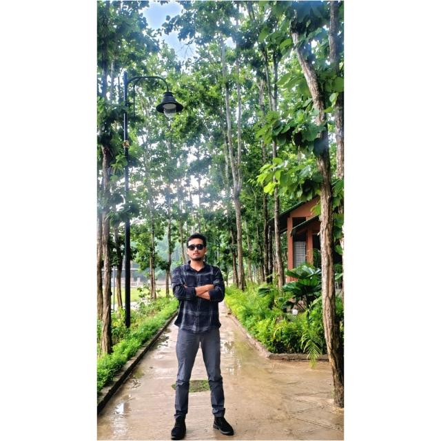 Ujjal Moni Bordoloi, founder of Gamosa, standing on a tree-lined path